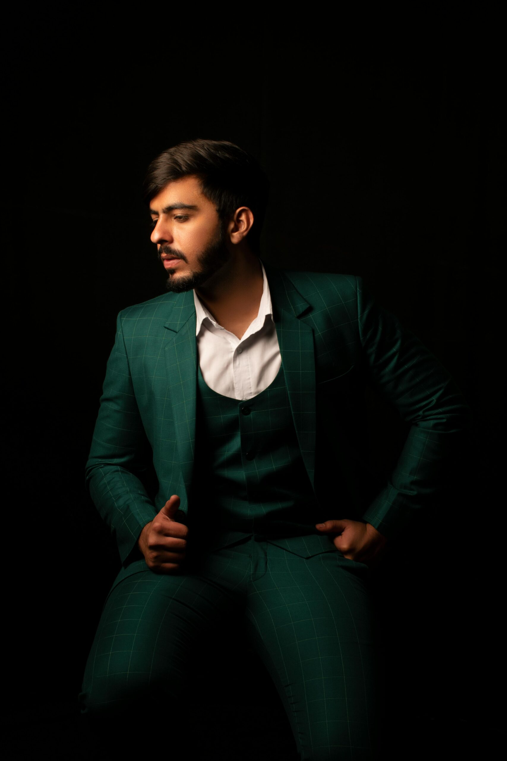 Stylish portrait of a man in a designer green suit. Studio lighting.